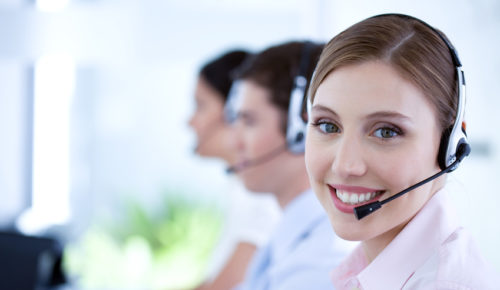 Happy woman wearing a headset working in customer care