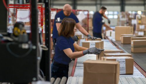 supply chain, men and women preparing shipments on conveyor belt