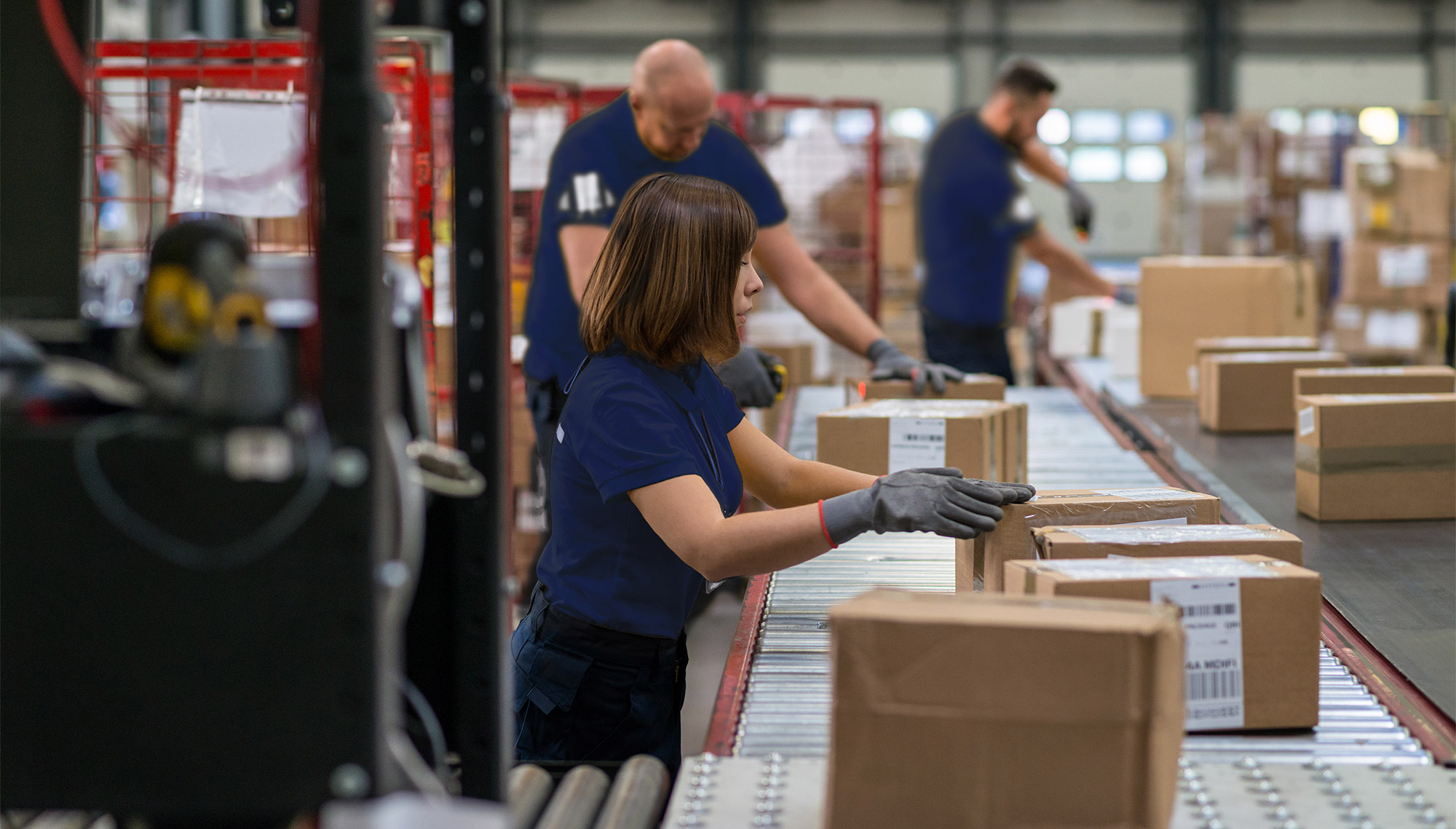 supply chain, men and women preparing shipments on conveyor belt