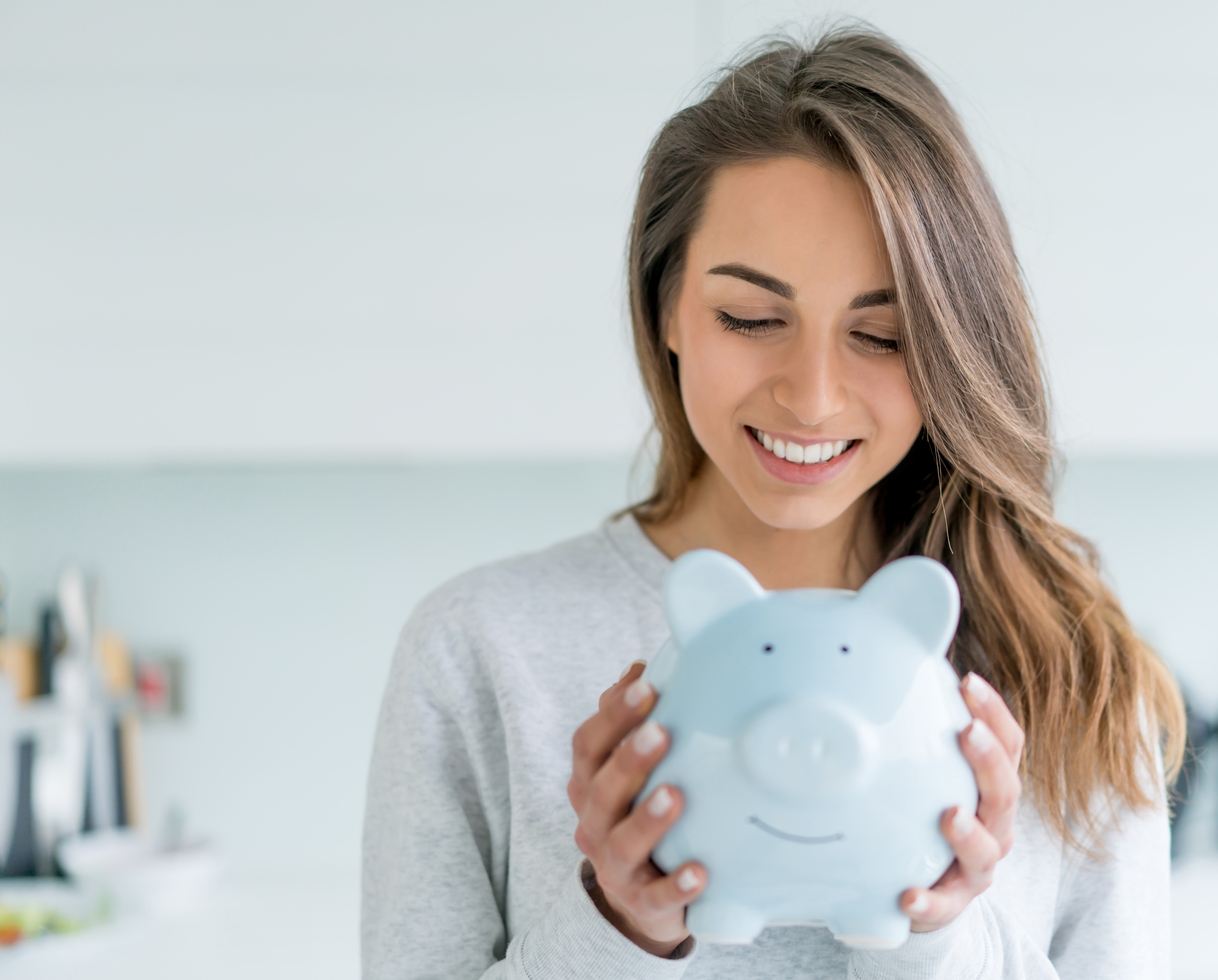 women smiling at piggy bank