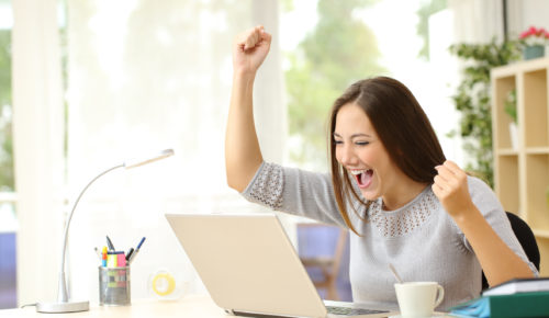 woman at computer excited about Black Friday, free shipping