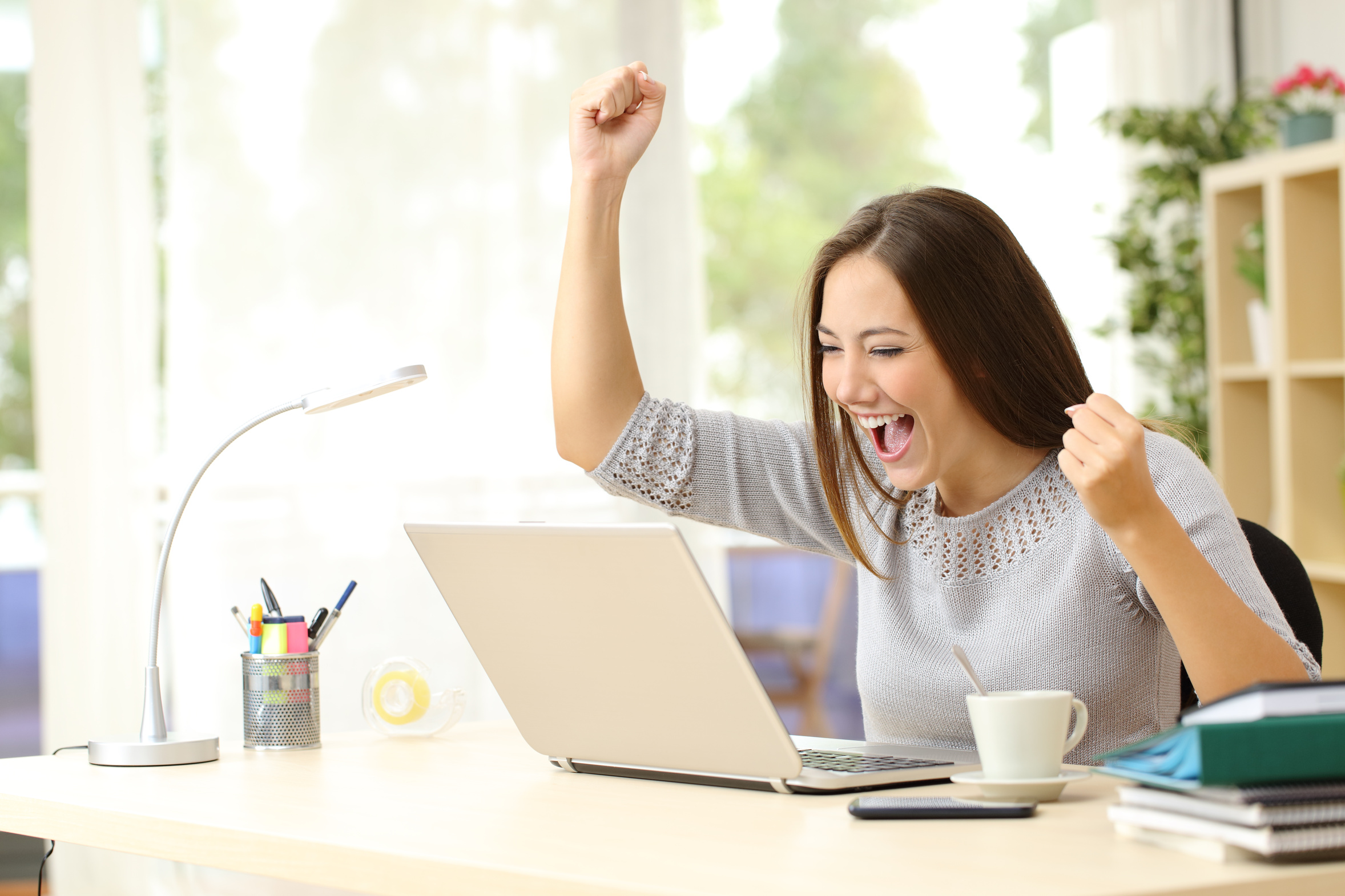 woman at computer excited about Black Friday, free shipping