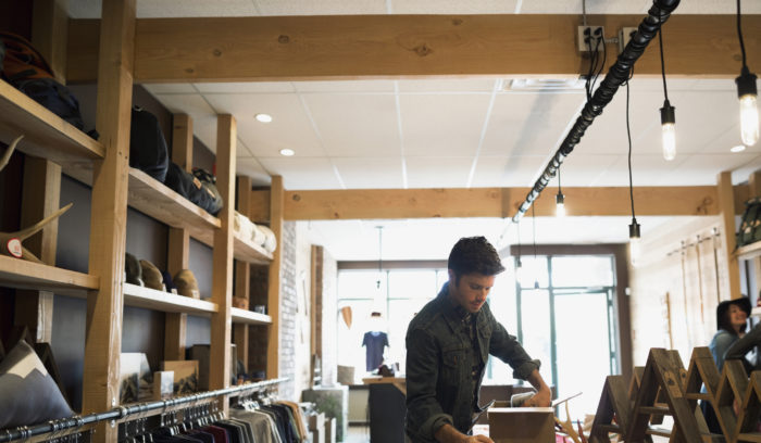 man in retail store packing delivery box, improving the last mile of delivery experience