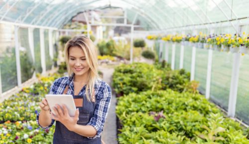 happy woman in flower shop with tablet  optimizing the last-mile of delivery experience