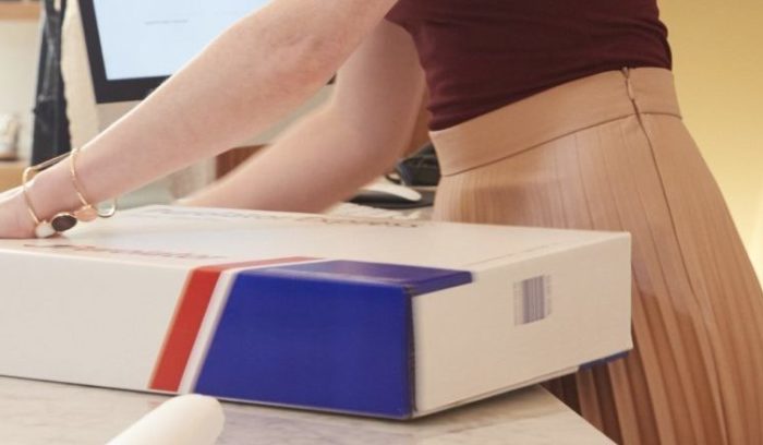 woman packing a Purolator box for return shipping