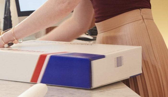 woman packing a Purolator box for return shipping