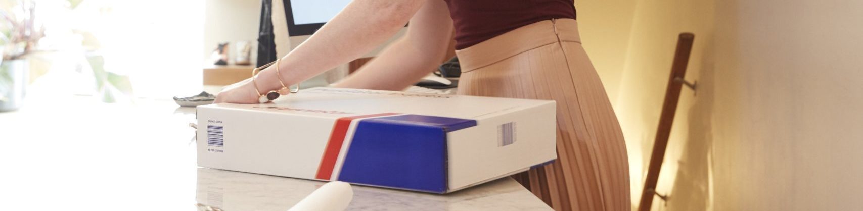 woman packing a Purolator box for return shipping