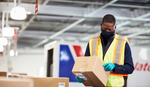 Purolator employee holding and looking at a box as part of delivery predictions and shipping logistics
