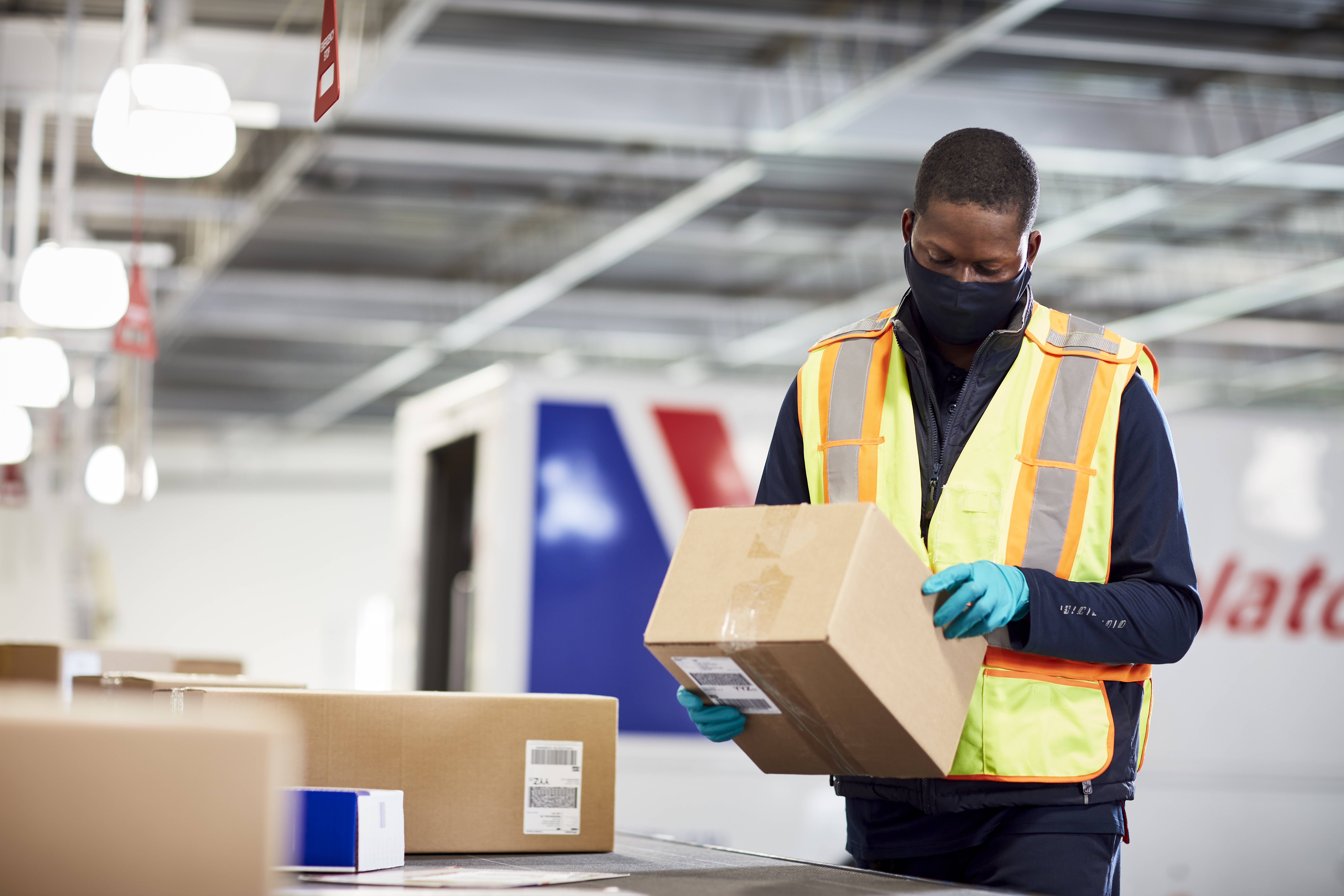 Purolator employee holding and looking at a box as part of delivery predictions and shipping logistics