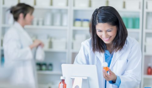 woman pharmacist acceoting prescription delivery and entering it into the computer system