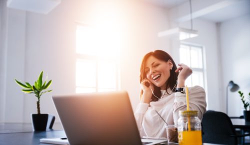 Woman smiling and listening to motivational songs for work