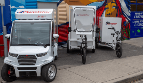 Purolator ebikes, green fleet and low emission vehicles parked in front of a storefront