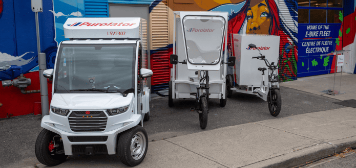 Purolator ebikes, green fleet and low emission vehicles parked in front of a storefront